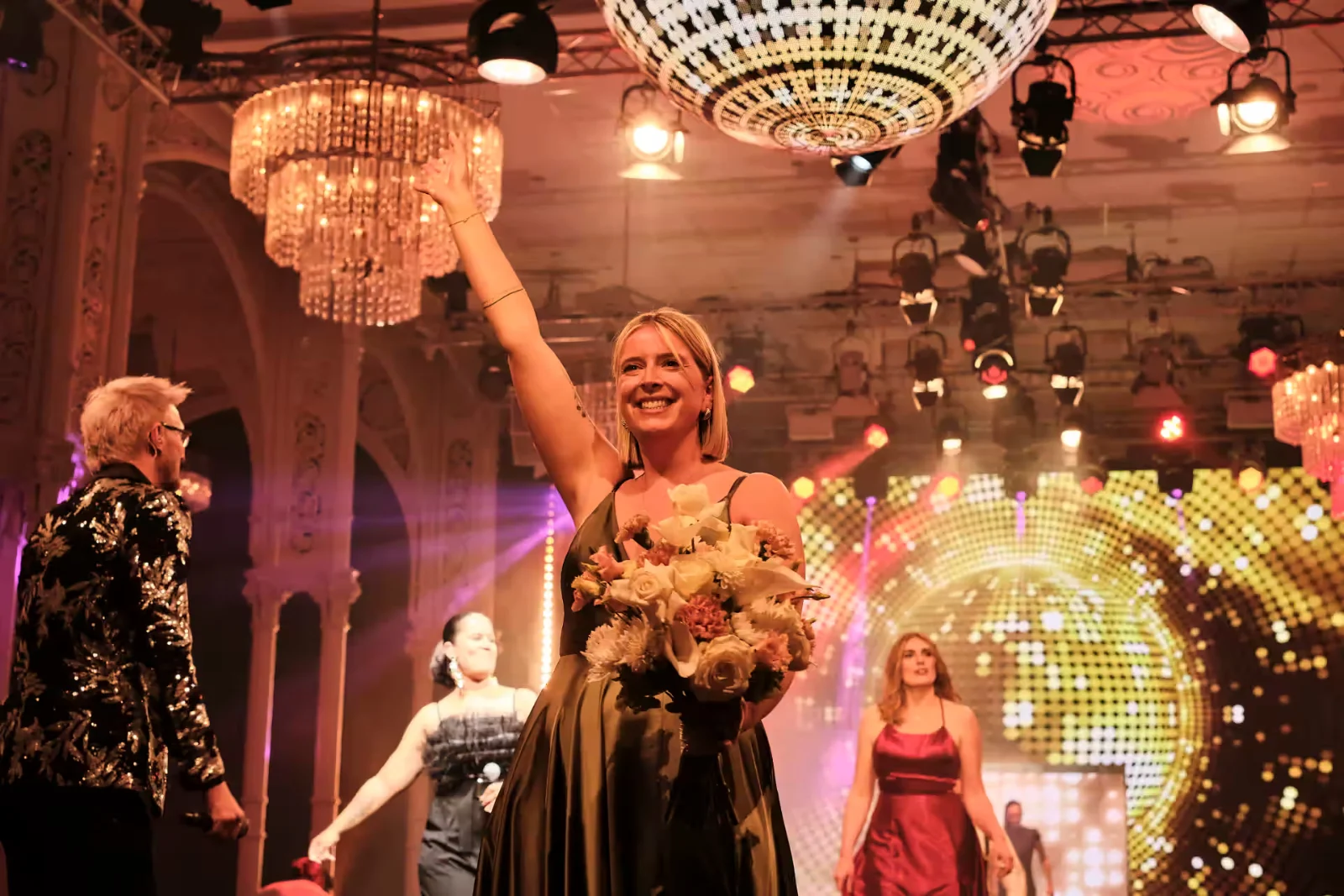 Gast im Publikum der Wedding King Awards jubelt mit erhobenen Armen zur Bühne