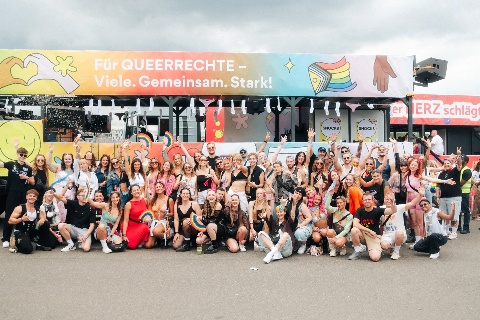 Gruppenfoto vor dem SNOCKS Truck beim Cologne Pride mit dem Banner Für Queerrechte