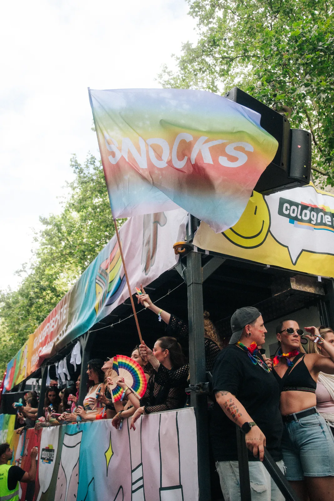 SNOCKS Flagge weht über dem Pride-Truck, Gäste feiern auf der oberen Ebene