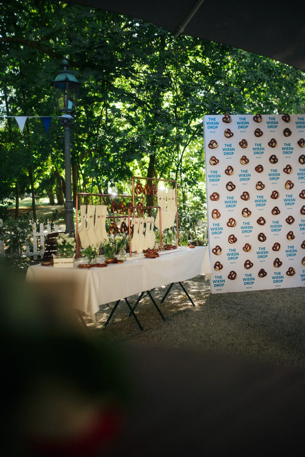 Gebrandeter Wiesn-Drop-Stand mit Socken, Brezeln und Fotowand im Biergarten