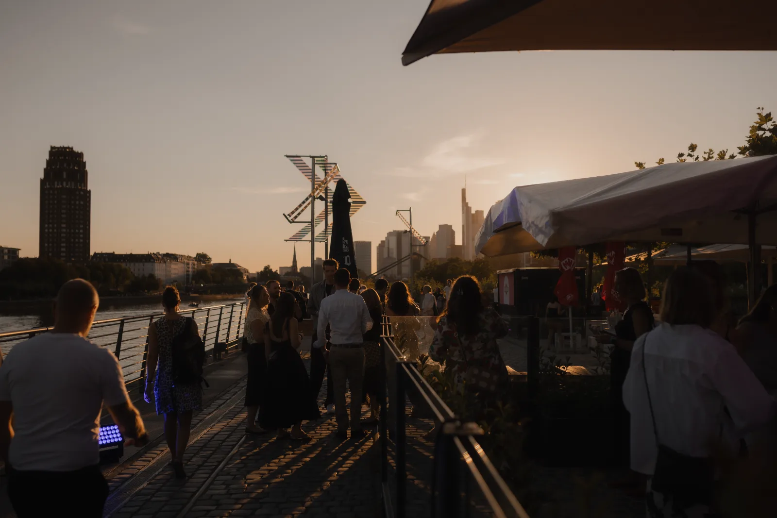 Abendveranstaltung des Merz Lifecare Summit am Mainufer mit der Frankfurter Skyline im Sonnenuntergang